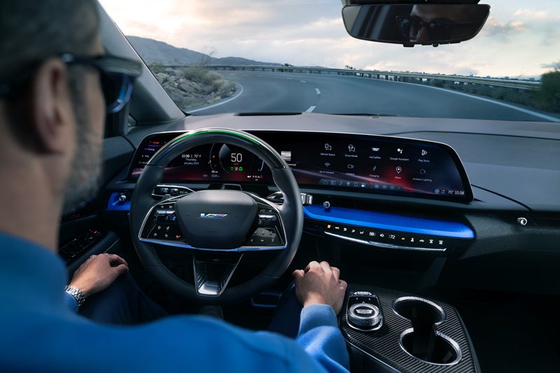 Front View of the 2026 OPTIQ-V Driving Through the Dusk Utilizing its Headlights | Cody Cadillac in Montpelier VT